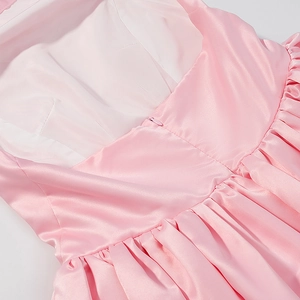 Detail of pink satin halter dress showing invisible zipper and pleated back waistline
