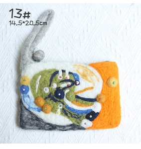 Close-up of handmade wool felt bag with colorful flower patterns and beaded textures