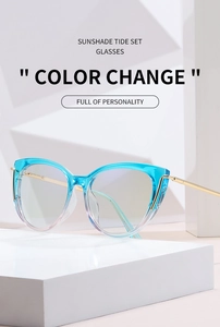 Detail of cat-eye sunglasses with blue gradient frames and golden metal temples on white stand