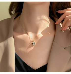 Close-up of a vintage black camellia pendant necklace with zircons on a model