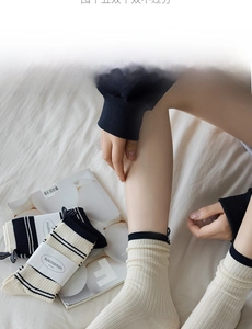 Detail of cream white and navy blue striped cotton socks with ribbed cuffs and packaging