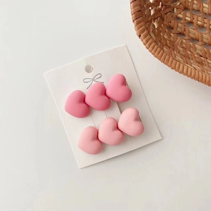 Detail shot of pink heart-shaped hair clips in matte finish on white display card