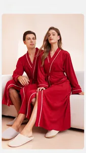 Detail of red long-sleeved bathrobe with white contrast trim and V-neck belted waist