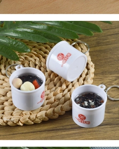 Macro shot of miniature Chinese porridge bowl keychain with realistic red date and lotus seed