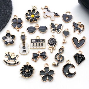Flat lay of black and white enamel DIY charms with gold alloy frames in various shapes