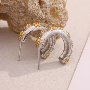 Macro shot of two-tone C-shape flower earrings with hammered metal texture