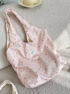 Floral print tote bag with pink fabric and colorful sozakka beauté label on fleece background