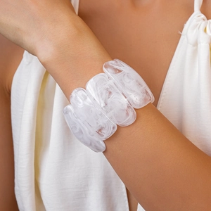 Detail of white marble acrylic wide cuff bracelet worn on wrist for vacation style