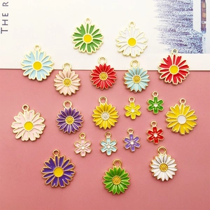 Flat lay of colorful enamel daisy alloy pendants in various sizes for DIY jewelry