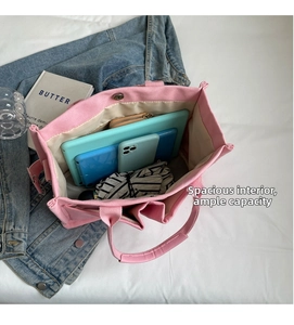 Vista interna di una borsa tote in tela rosa con tasche multiple e ampio spazio