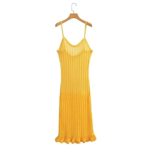 Gelbes Strick-Maxikleid mit Lochmuster, Volantsaum und dünnen Trägern vor weißem Grund