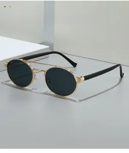 Detail of vintage round sunglasses with gold double bridge metal frame and black temples