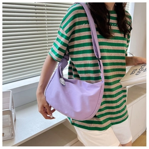 Detail of lavender hobo bag with wide shoulder strap and white cartoon dog pendant