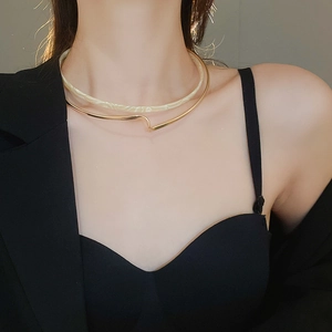 Detail view of double-layered resin and gold collar necklace on a model wearing black