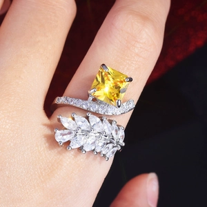 Radiant cut yellow diamond ring with marquise leaf accents in polished silver setting