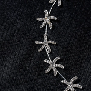 Detailed macro view of golden starfish headpiece with sparkling rhinestones and ribbon