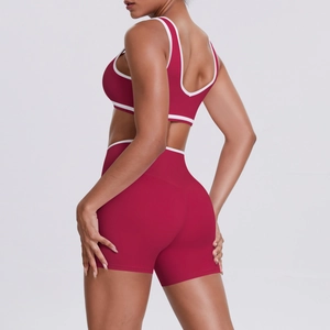 Macro detail of the contrast stripe trim on burgundy high-waisted fitness shorts