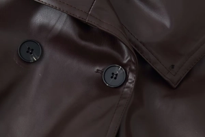 Detailaufnahme der dunkelbraunen Kunstlederjacke mit Marmorknöpfen und feiner Nahtführung