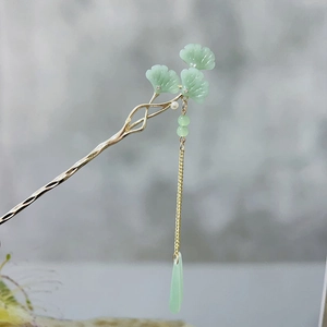 Detail of golden ginkgo leaf hair pin with green tassels and a white pearl accent