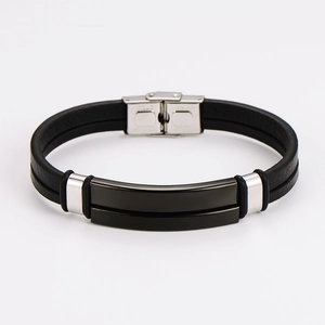 Detail of multi-layer black braided leather bracelet with stainless steel clasp and engraving
