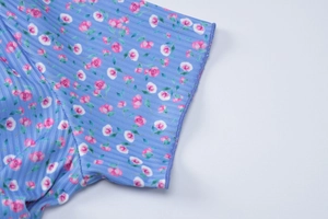 Detailaufnahme des himmelblauen Blumenstrickstoffs mit verstärkter Kantennaht-Struktur