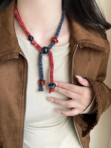 Close-up of bohemian woven cotton cord necklace with multicolored resin beads and texture
