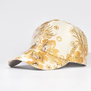Detail of cream baseball cap featuring golden floral jacquard and oriental satin texture