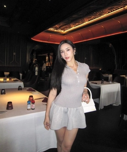 Robe polo grise ajustée en maille avec jupe plissée dans un cadre de restaurant chic