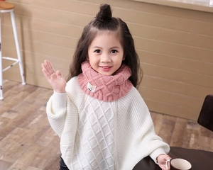 Detail of pink knitted winter neck warmer for kids with soft diamond pattern sweater