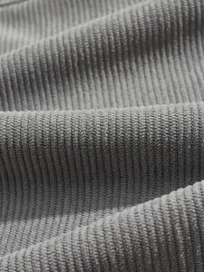 Macro shot showing the fine texture and soft folds of gray corduroy sports suit fabric