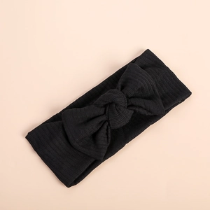 Detail of black ribbed knit baby headband featuring a large soft textured bow