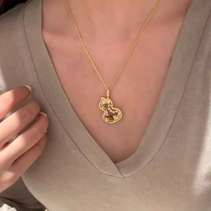 Elegant gold gourd necklace with inlaid pearls and diamonds worn by a model