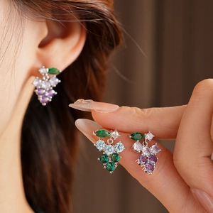 Detailed close-up of grape-shaped tassel earrings with purple, blue, and green crystals