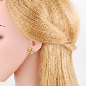 Detail of cute golden balloon dog stud earring with green enamel inlay on ear model