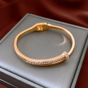 Detail of gold nail bracelet featuring pavé crystals and side hinge closure