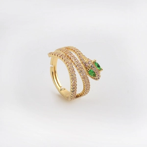 Dettaglio anello a serpente dorato con cristalli rosa e occhi in zircone verde