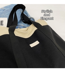 Close-up of contrast canvas tote bag showing the textured black fabric and logo detail
