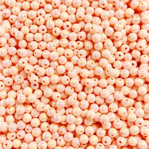 Macro shot of peach round luminous beads with iridescent finish for jewelry making