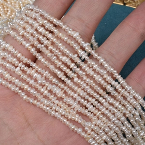 Strands of 2.5mm natural freshwater mini pearls with high luster on green velvet