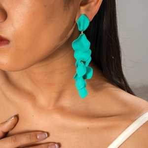 Macro shot of long teal resin drop earrings featuring matte petal-shaped geometric segments