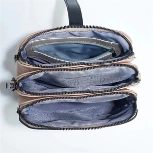 Top view showing three main zipper compartments and geometric lining of the crossbody bag
