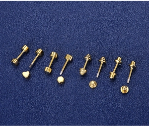 Macro detail of various gold-plated screw-back cartilage stud earrings on a blue background