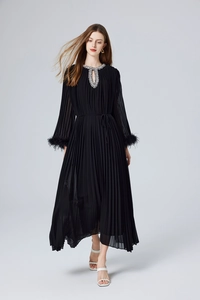Détail d'une robe noire plissée avec des poignets en plumes et un col en strass chic