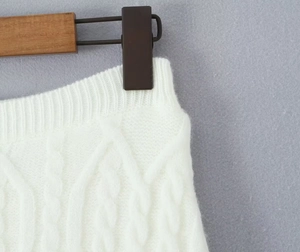 Detail shot of white cable knit fabric texture and elastic waistband of the skirt set