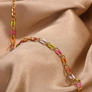 Macro shot of 18K gold plated stainless steel chain bracelet with colorful enamel links
