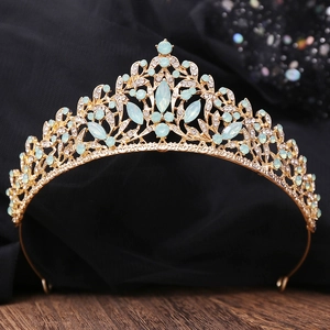 Baroque golden bridal tiara with light blue gemstones and crystals on black background