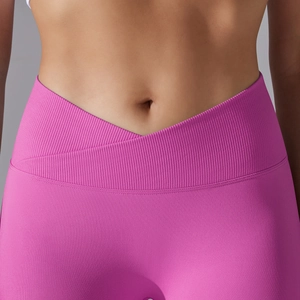 Detail of high-waist yoga leggings featuring a pink crossover V-waistband and ribbed texture
