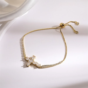 Detailed view of adjustable gold cross bracelet with shimmering pavé cubic zirconia