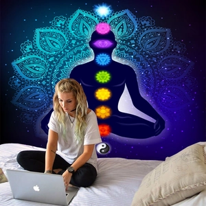 Detail of meditation tapestry with 7 chakra symbols and mandala in a cozy bedroom setting
