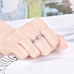 Detail of heart-shaped silver open ring with a round brilliant cut solitaire diamond